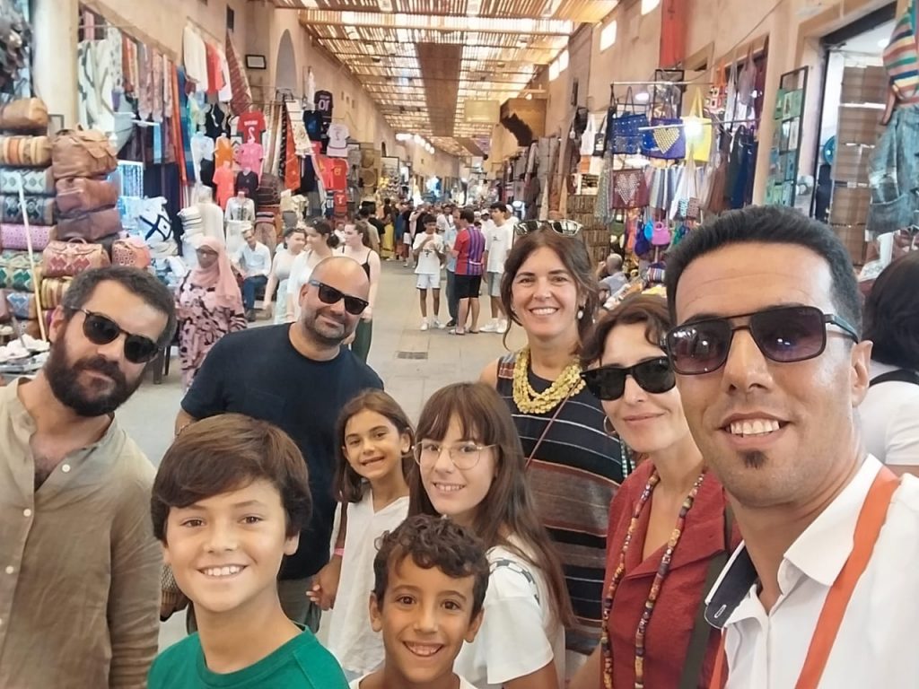 Viaje a Marruecos con adolescentes Experiencias en Marrakech: Foto grupal en un mercado callejero de Marrakech
