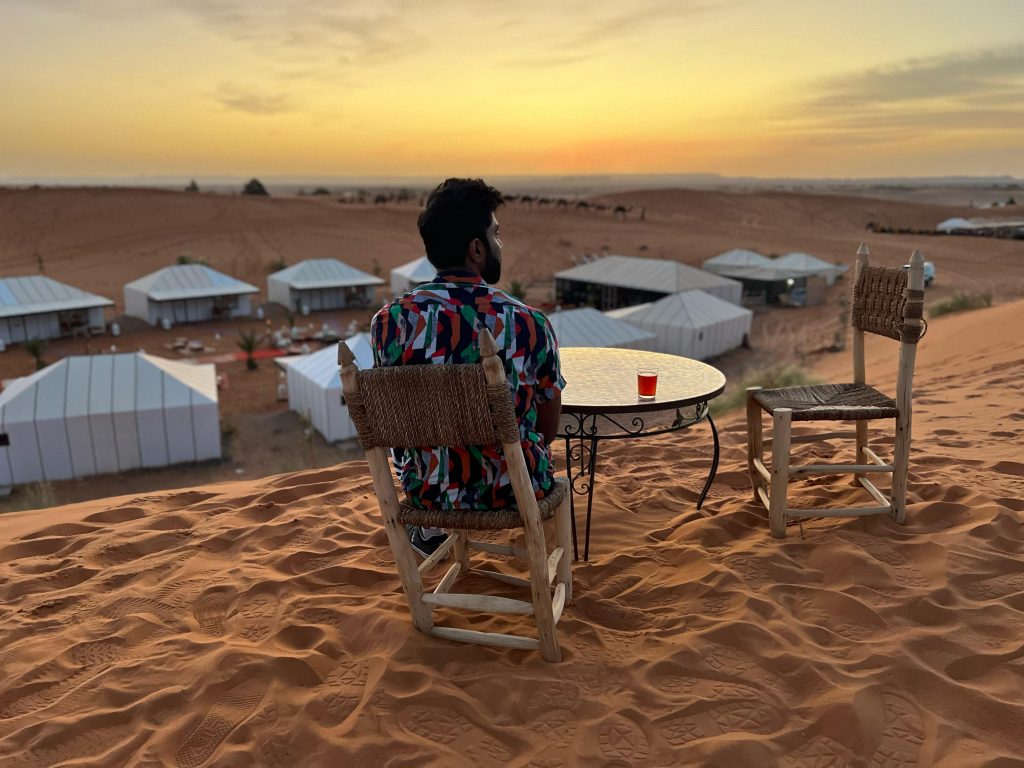 Persona sentada en mesa en medio del desierto.