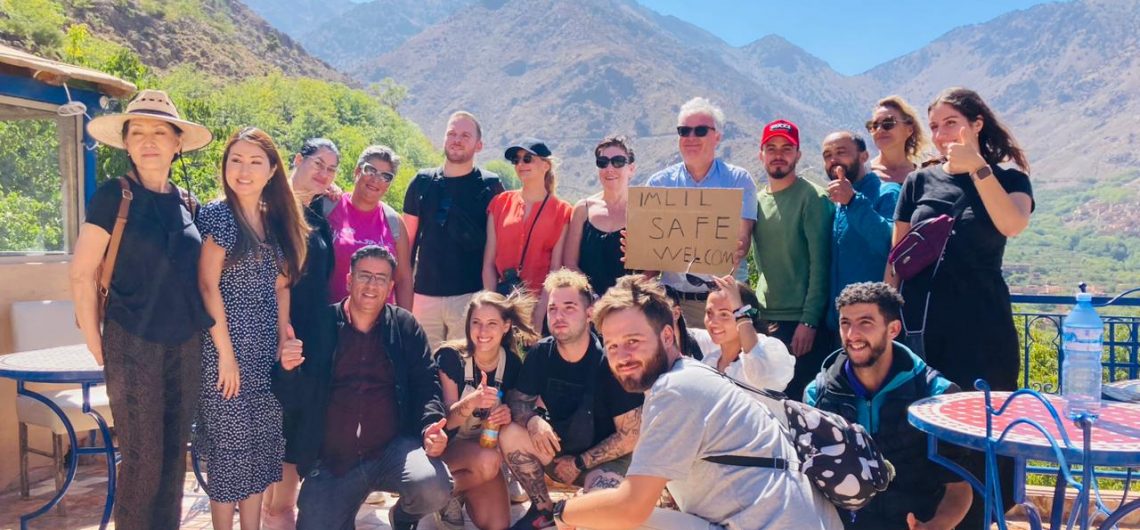 Grupo de viajeros posando con montañas al fondo.