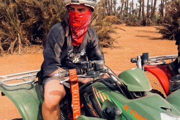 Viajero posa sobre un quad en el desierto