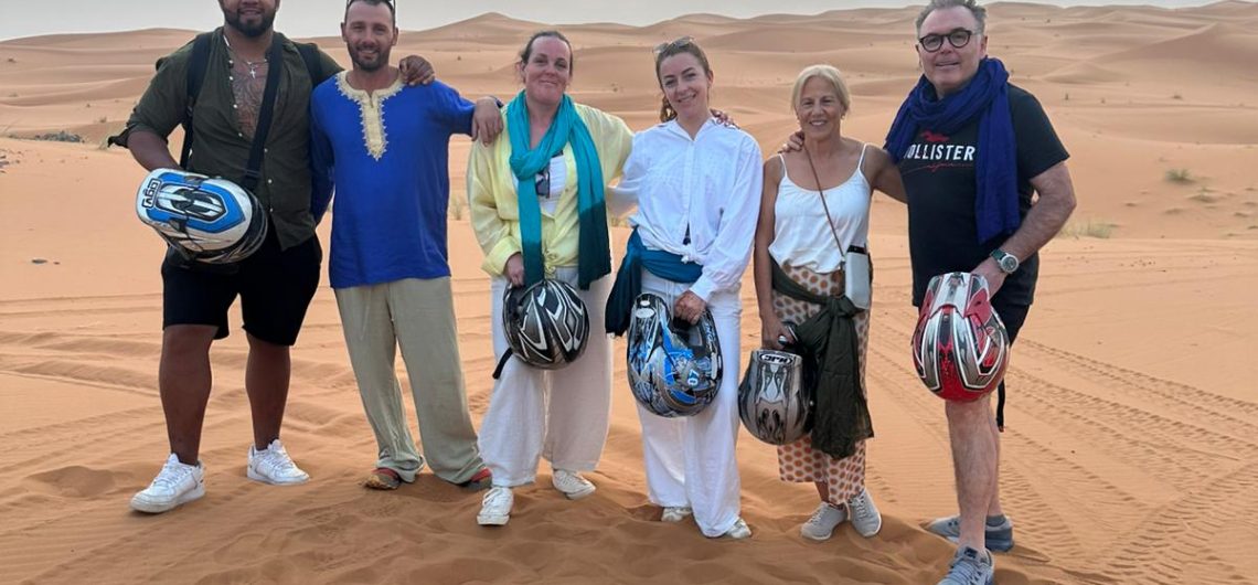 tour desierto Marrakech 4 días Grupo de turistas posando con casos de quad.